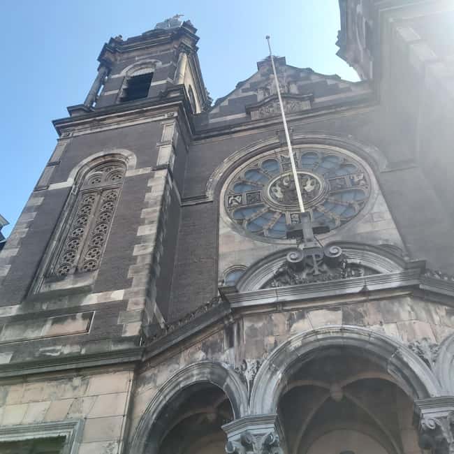 Amsterdam: Spanish Tour Unmasking the Redlight District - Oude Kerk and the older layers that give the story weight