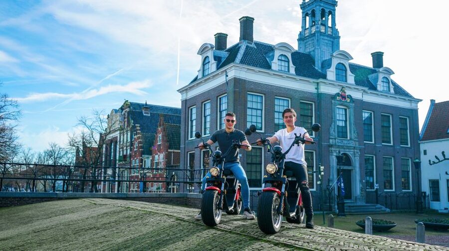 Volendam: E-Scooter Rental - Monnickendam stops: bronze-brick houses, harbor terraces, and beer